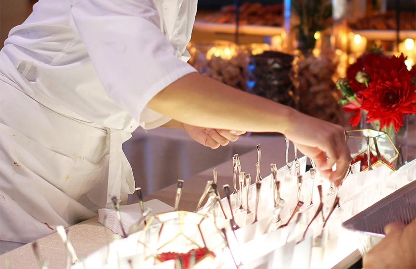 A chef positions canapés in a fine dining setting