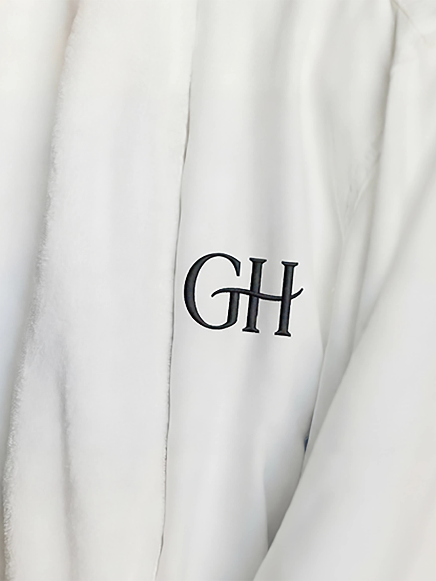 A white, branded plush bathrobe, available within the luxury guest suites at the Glenhill Hotel in North York.
