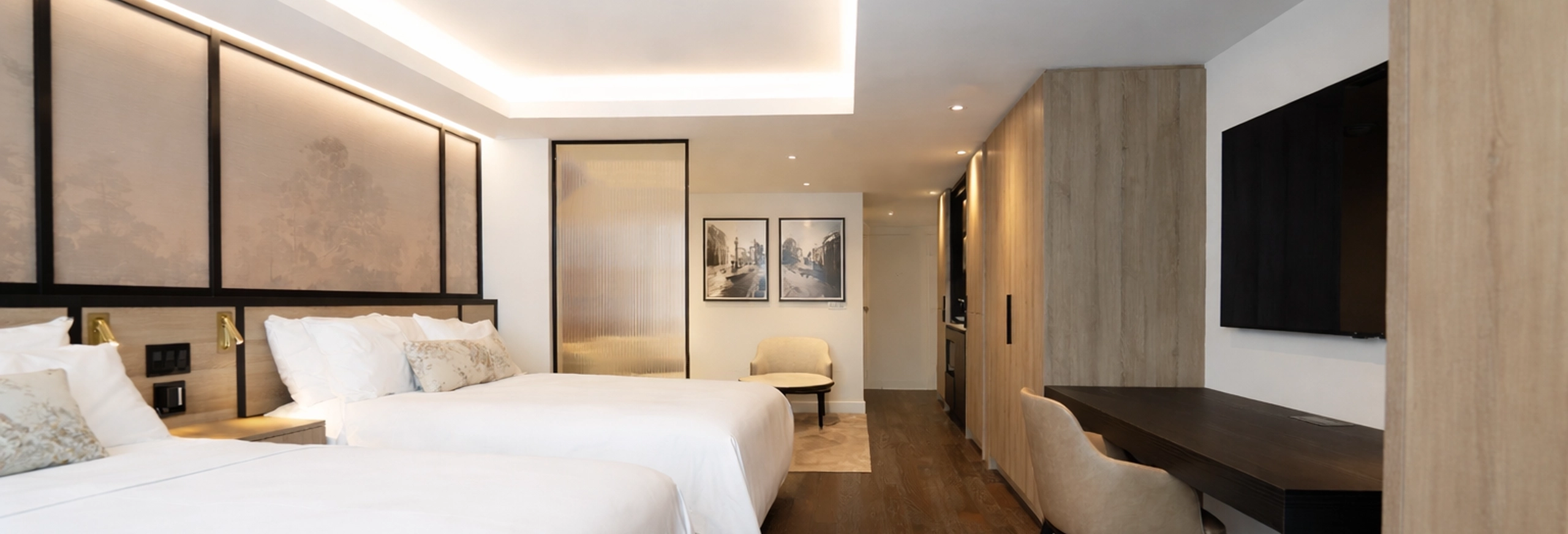 Luxury hotel suite at The Glenhill Hotel North York featuring two queen-size beds with premium white linens, high-end headboards, and elegant boutique finishes