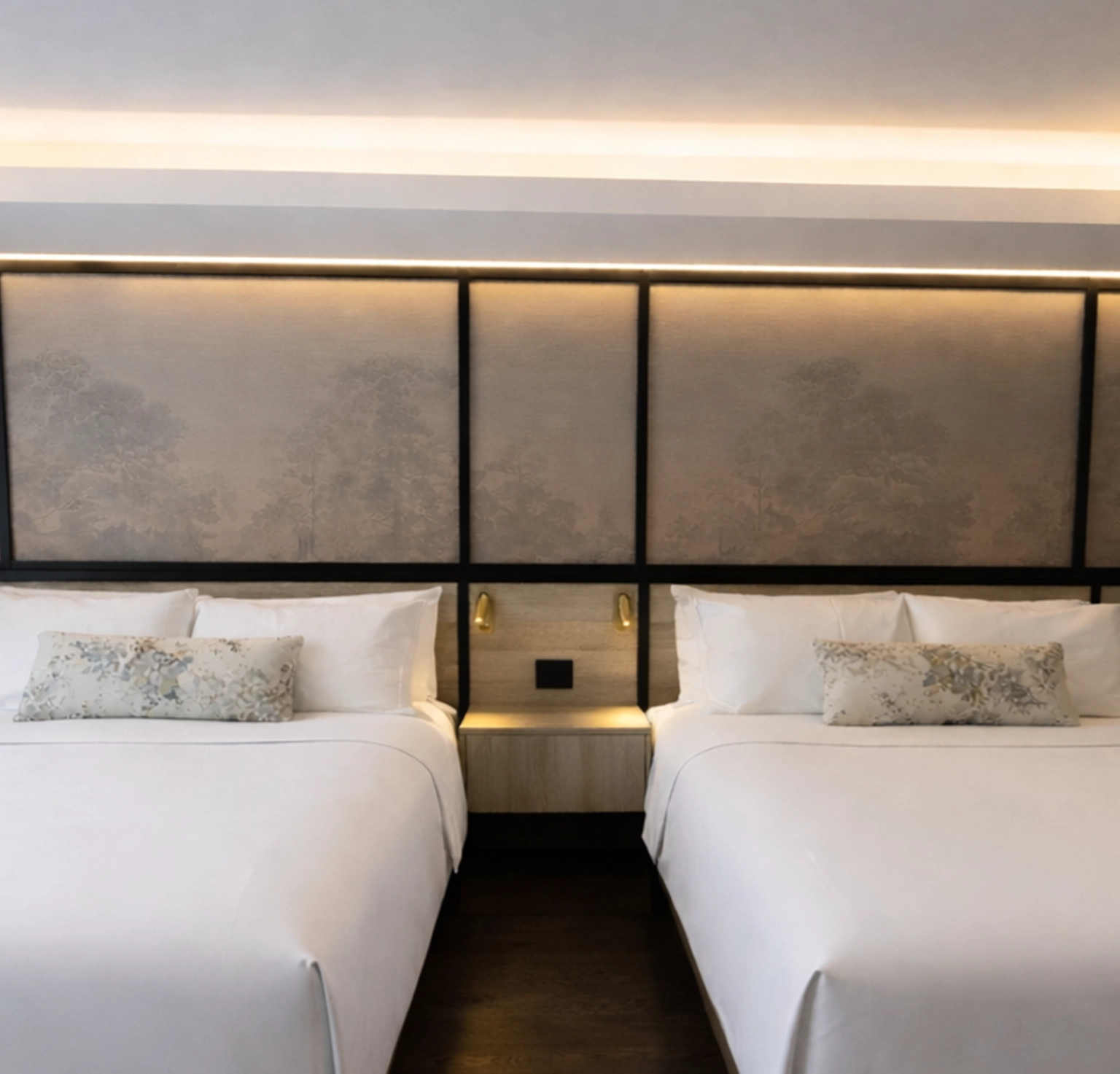 Luxury hotel suite at The Glenhill Hotel North York featuring two queen-size beds with premium white linens, high-end headboards, and elegant boutique finishes