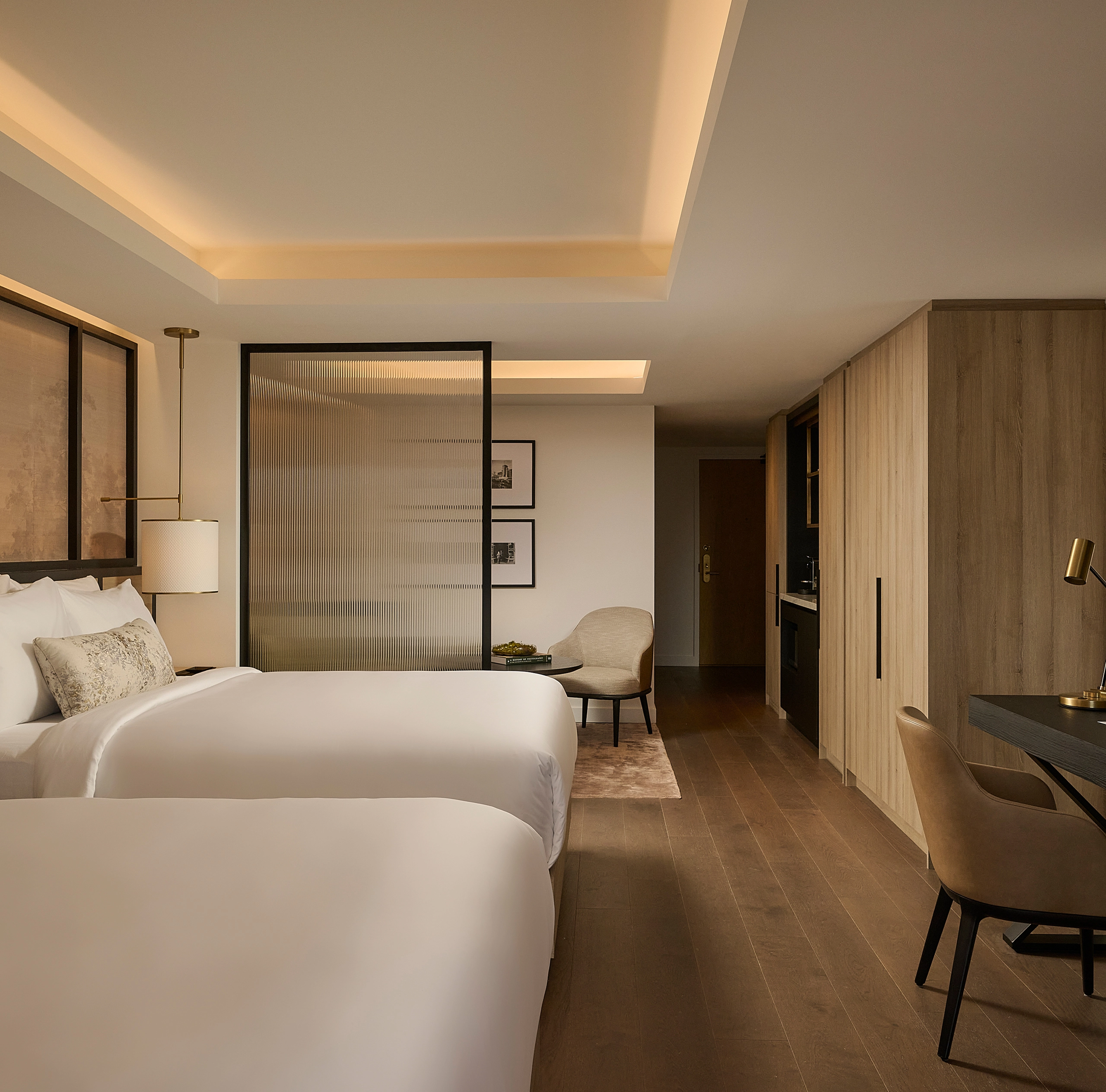 Luxury hotel suite at Glenhill Hotel North York featuring two queen-size beds with premium white linens, high-end headboards, and elegant boutique finishes